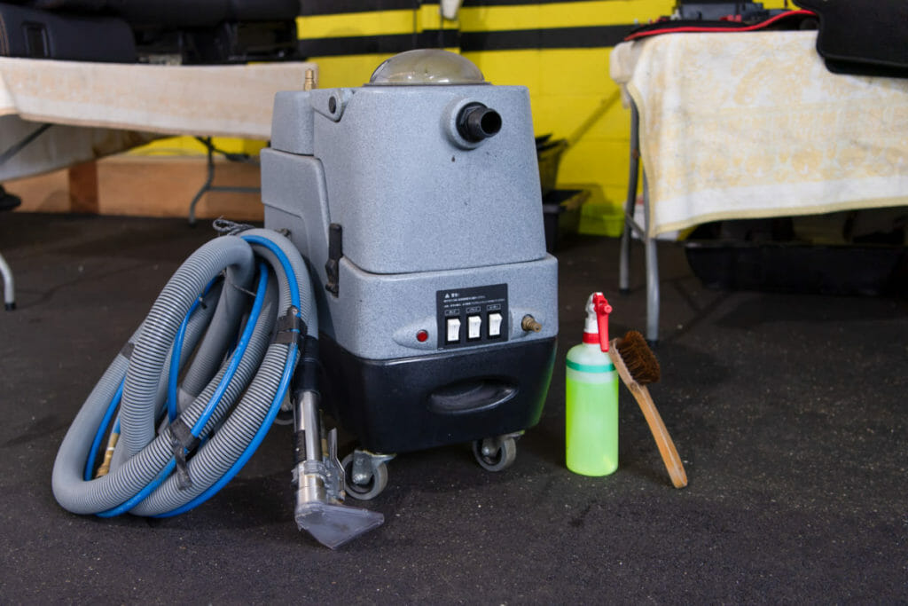 ホースとノズルがついた業務用のホットリンサーと、スプレーボトル、ブラシ